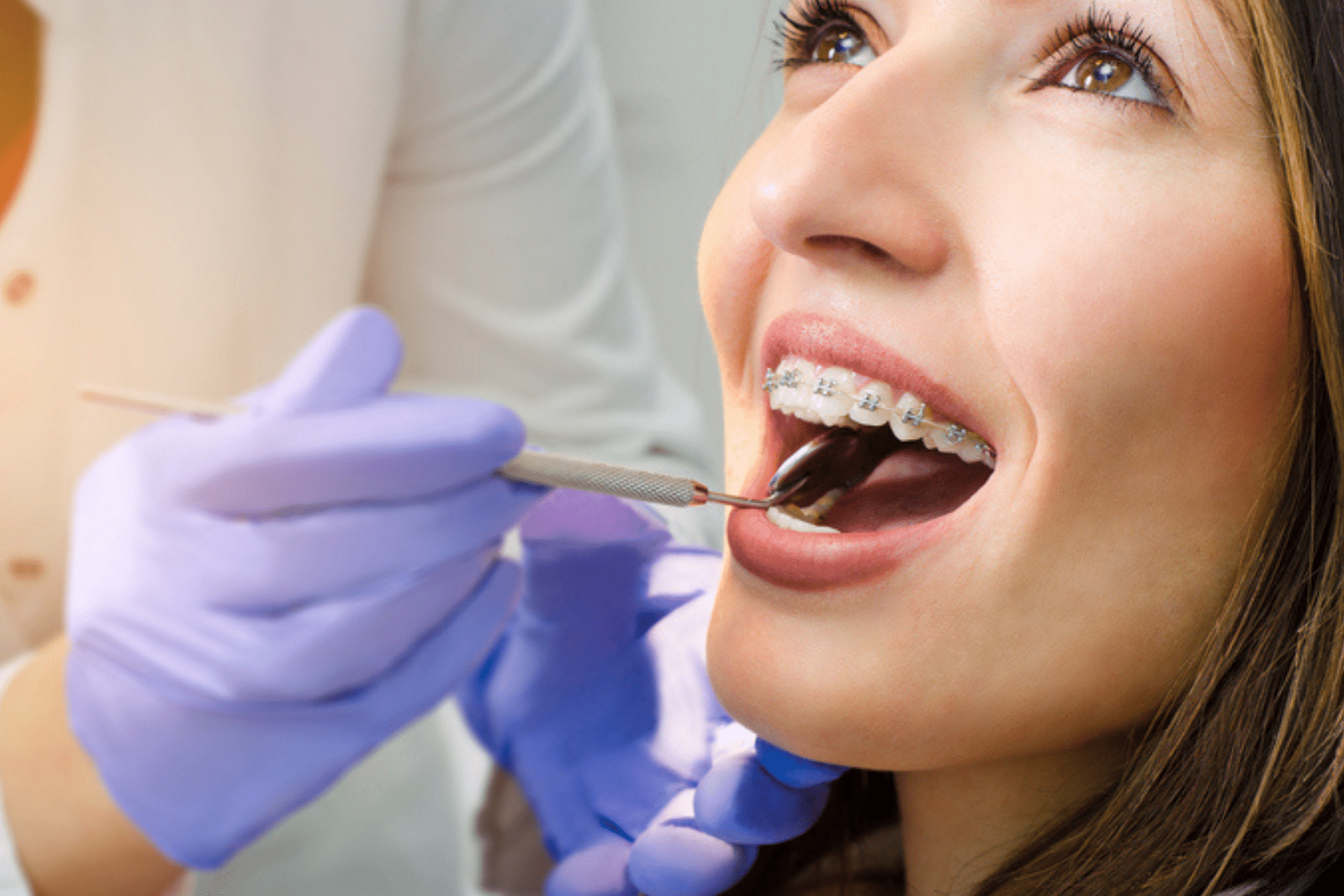 Close-up of a woman with metal braces getting an examination