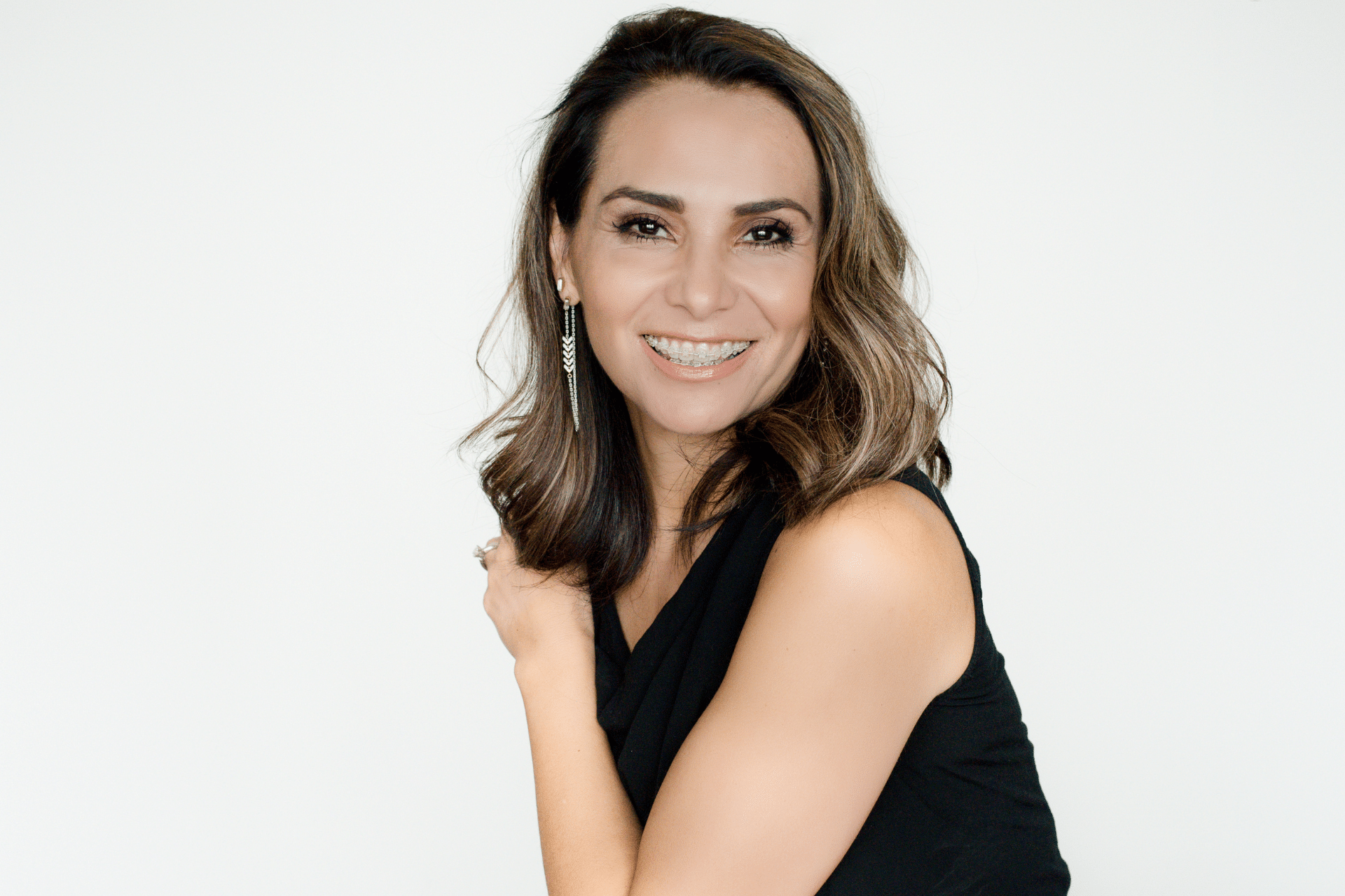 Adult woman smiling while wearing clear ceramic braces